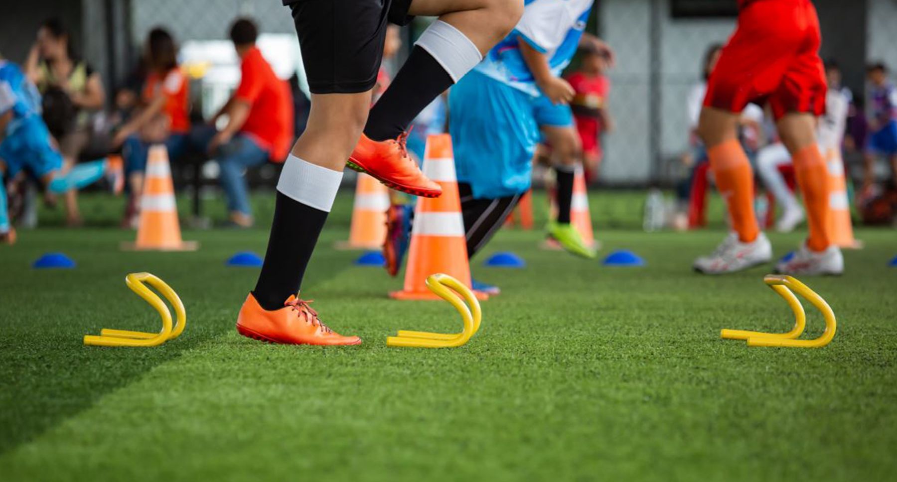 Jeunes athlètes à l'entraînement d'agilité sur un terrain synthétique